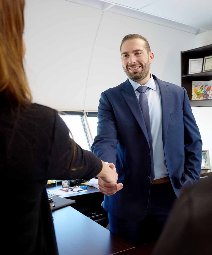 Lawrence A. Kajy, Esq shaking hands with client in office