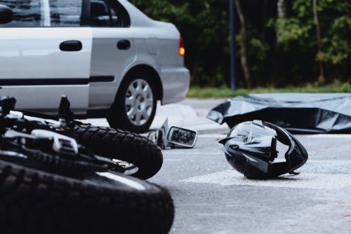 Michigan motorcycle accident lawyer image of motorcycle crash scene with helmet on road after collision
