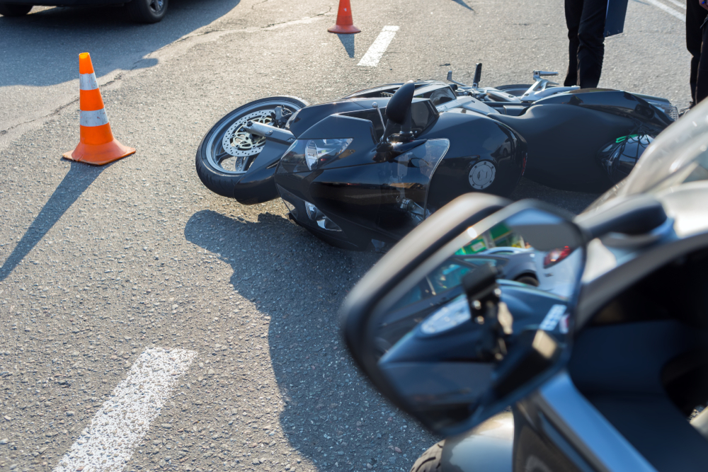 Michigan motorcycle accident information image of fallen motorcycle at crash scene with traffic cones on road