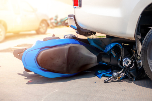 Michigan motorcycle accident lawyer image of motorcycle trapped under vehicle after crash