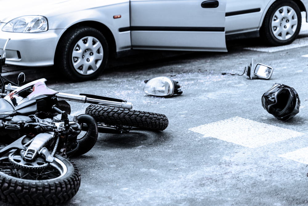 Michigan motorcycle accident lawyer image of motorcycle crash scene with helmet and debris on road after collision