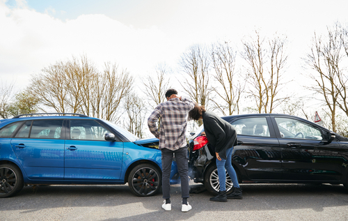 Michigan car accident lawyer image of drivers inspecting car damage after crash