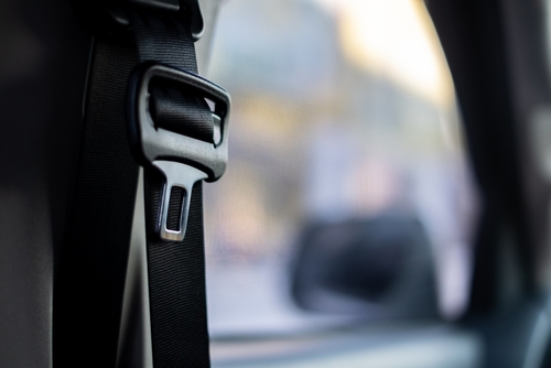 Michigan personal injury lawyer explains seat belt law with close up of secured seat belt buckle