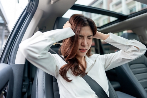 Michigan car accident lawyer helps you claim emotional distress damages with person showing stress after crash